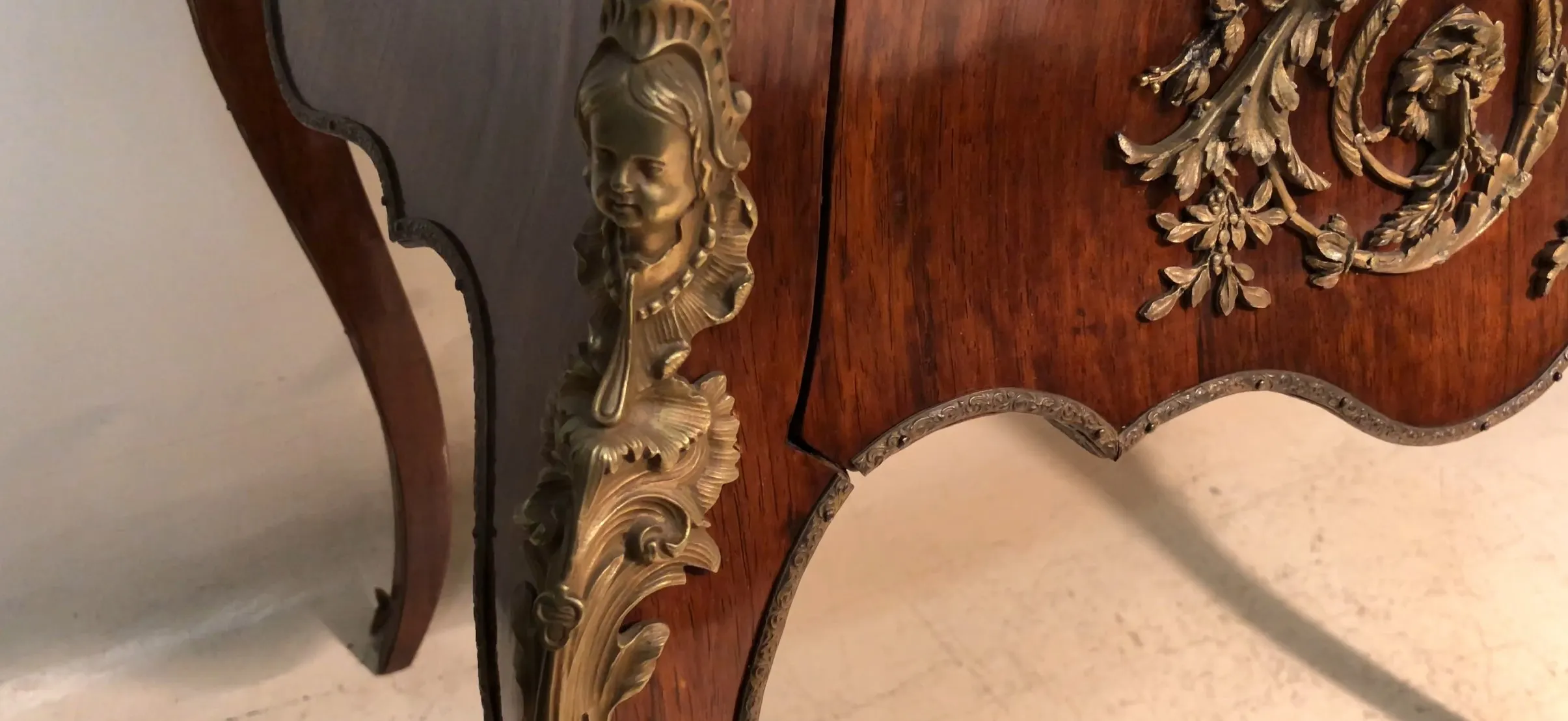 مكتب قديم بتفاصيل بارزة وأرجل مزخرفة.