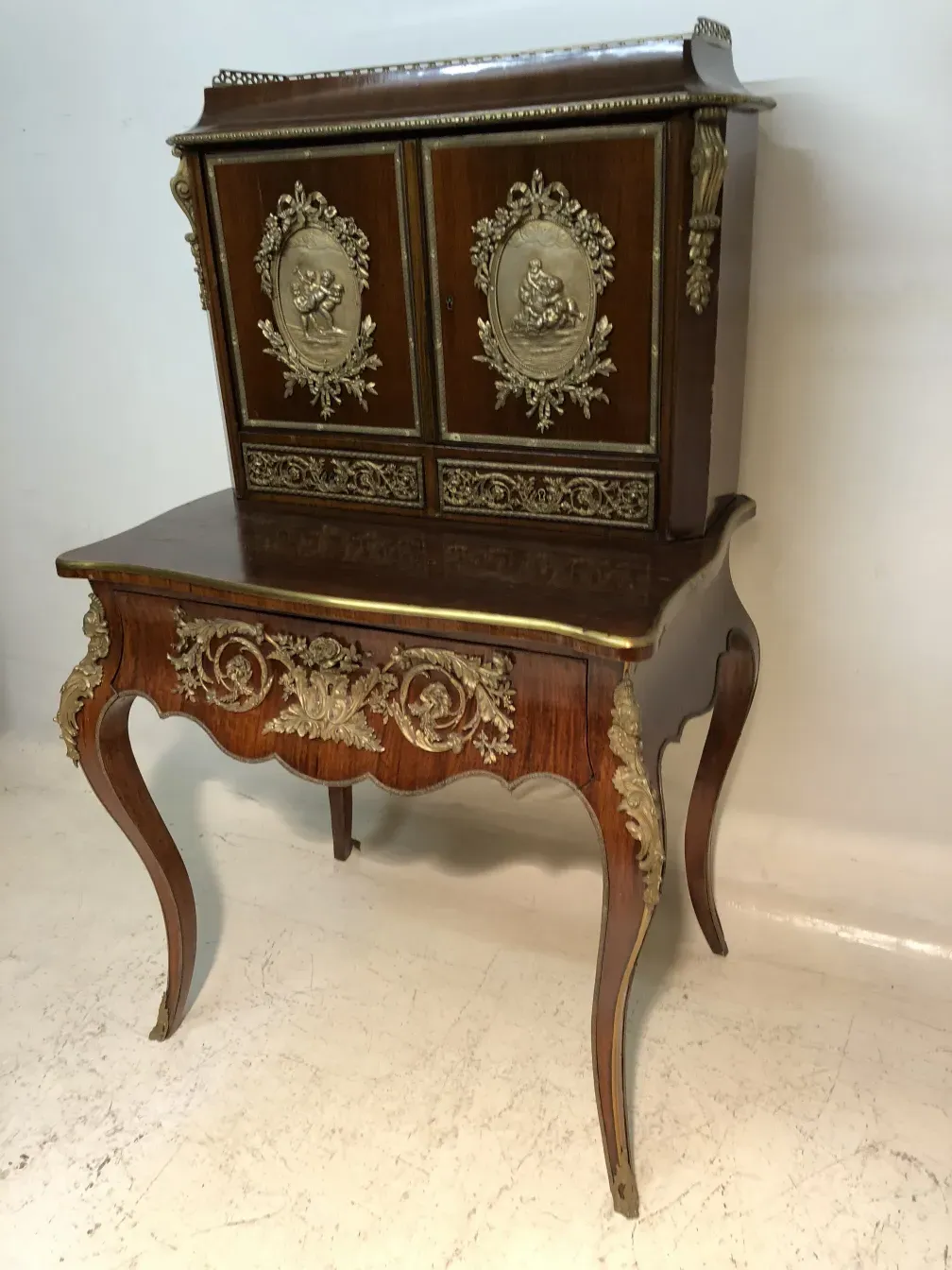 Escritorio antiguo con dos cajones decorativos y tallas