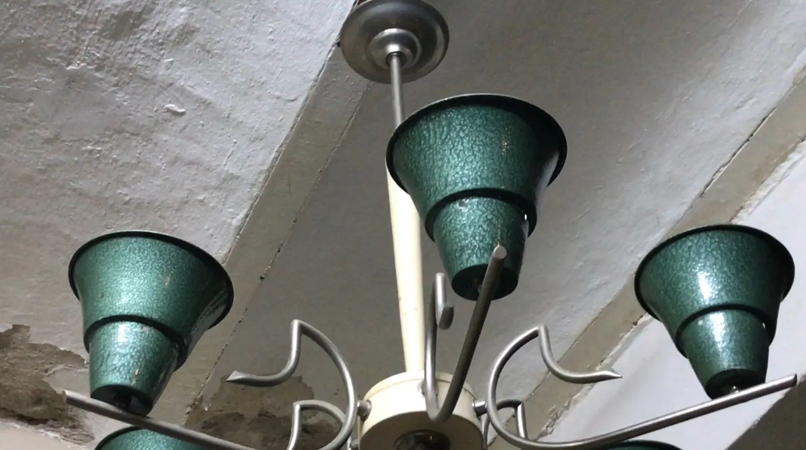 Lampada a sospensione antica con paralumi verdi che illumina la stanza