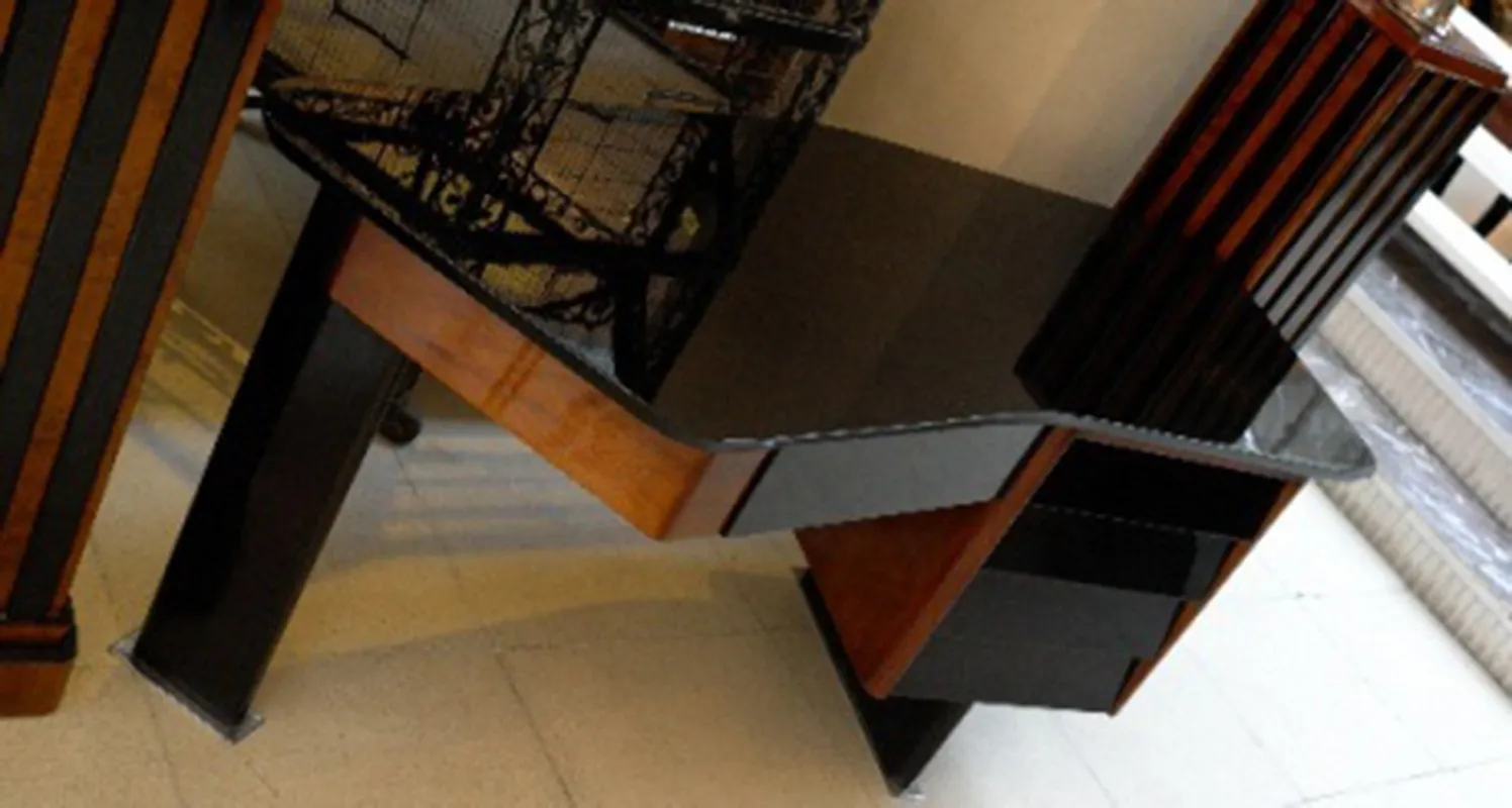 Antiker Schreibtisch mit schwarzer Oberfläche und modernen Linien in einer eleganten Umgebung.