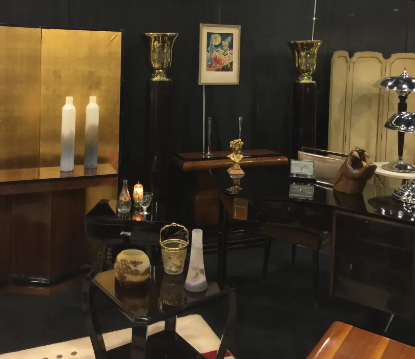 Antiker Schreibtisch, der elegante Dekorationen und verschiedene Zubehörteile zeigt.