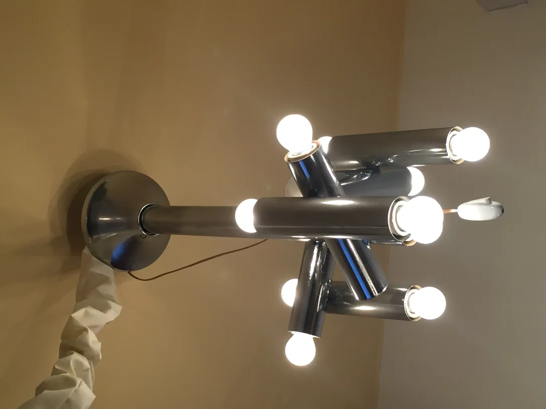 Lámpara de techo antigua con múltiples bombillas iluminando el ambiente.