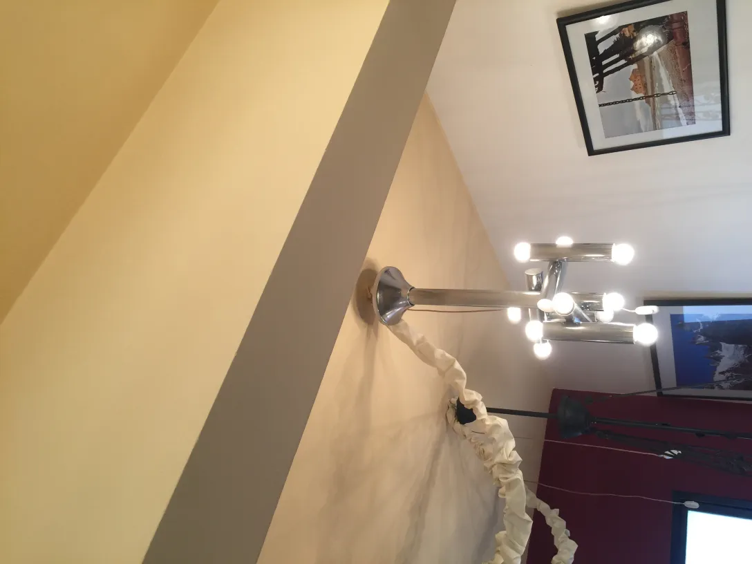 Lampada a sospensione antica con molte lampadine in un contesto moderno.