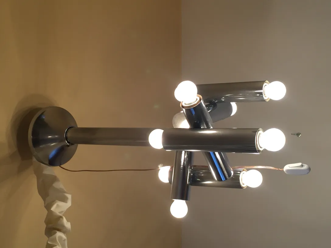 Antique hanging lamp with multiple tubular bulbs illuminating a room