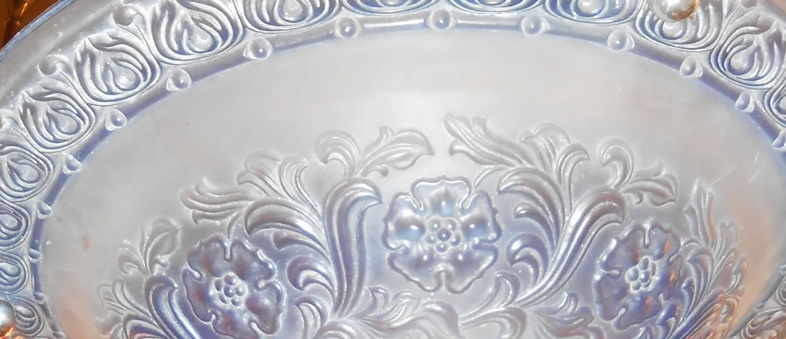 Lampada a sospensione antica con design floreale sul bordo.