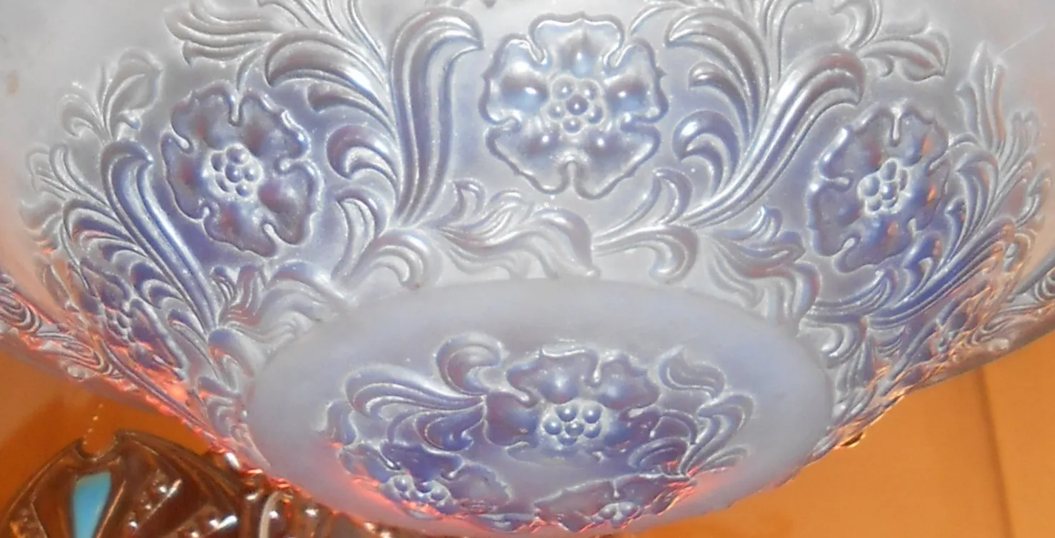 Lustre ancien avec design floral en tons doux, ambiance élégante.