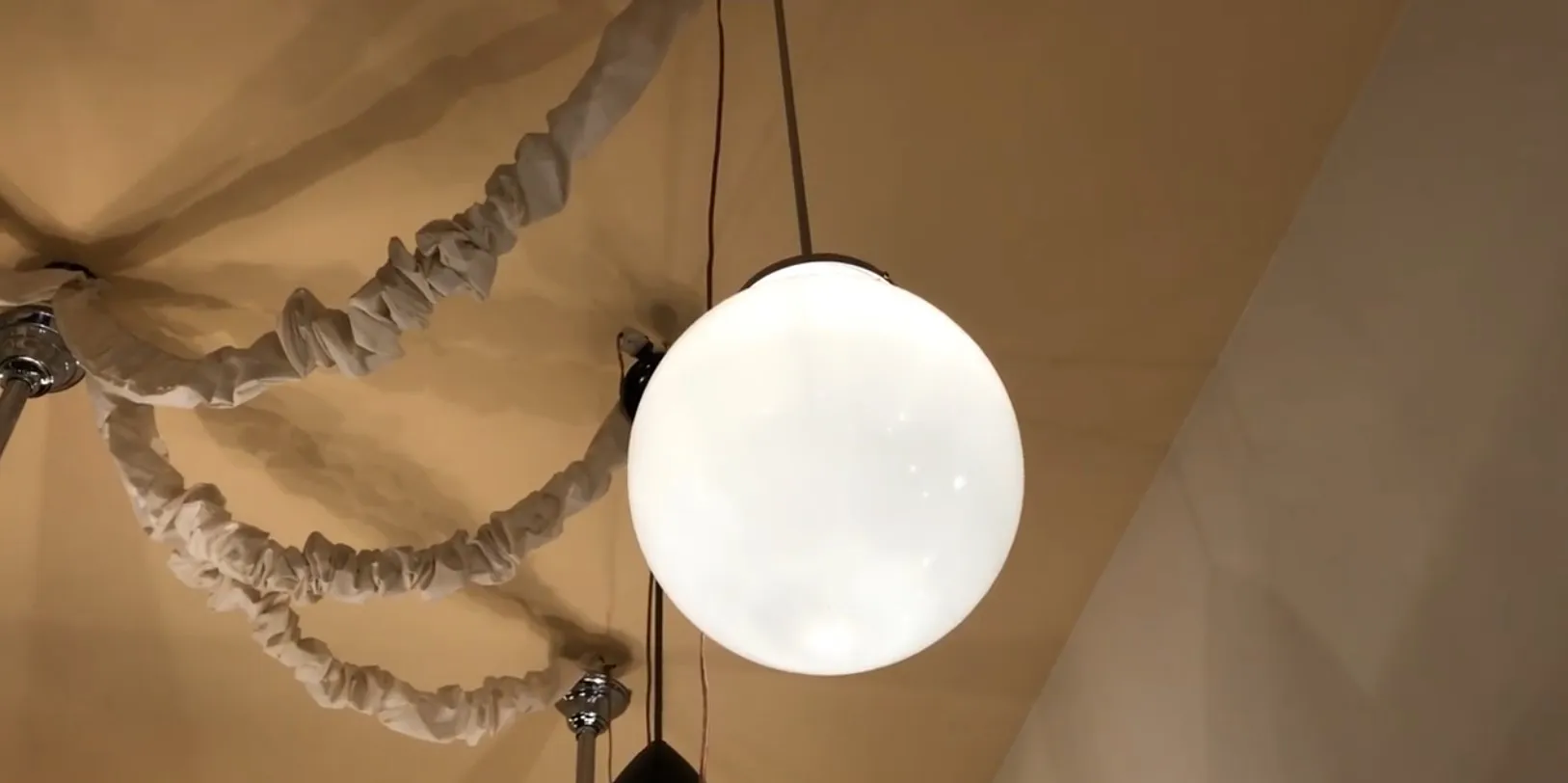 Antique hanging lamp with a white sphere, cozy setting.