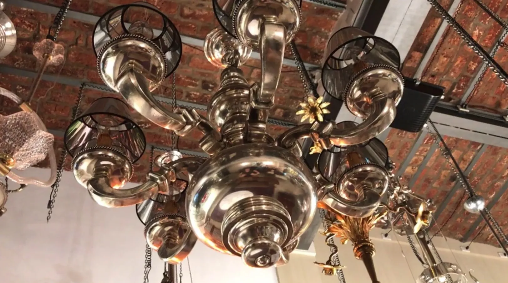 Lâmpada de teto antiga com braços elegantes e detalhes dourados, ambiente acolhedor.