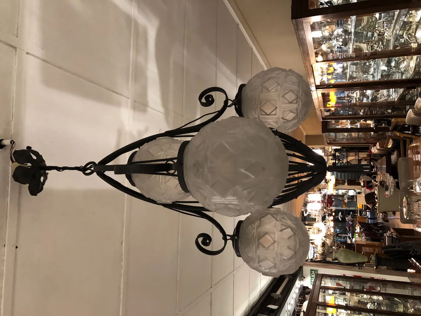 Lámpara de techo antigua con detalles de vidrio y fondo de antigüedades.