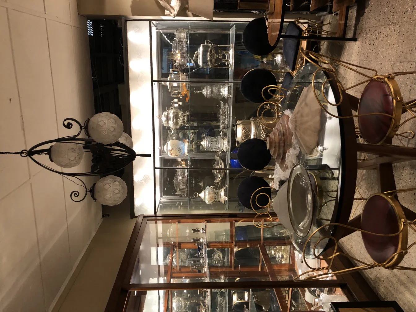 Lustre antigo de vidro com seis globos, ambiente elegante.