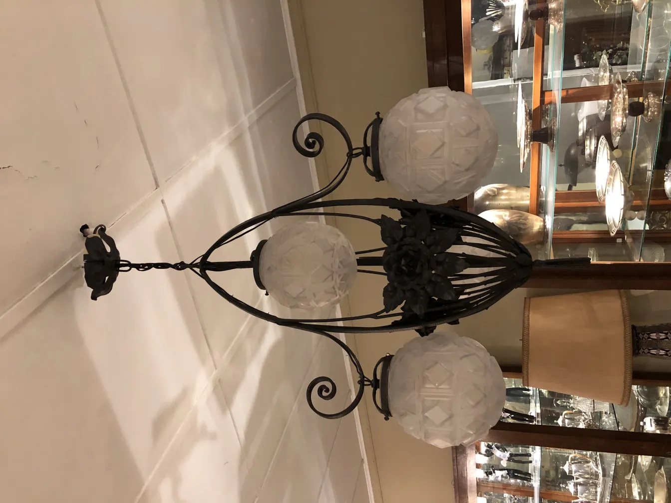 Lâmpada de teto antiga com globos brancos de vidro em um ambiente acolhedor.