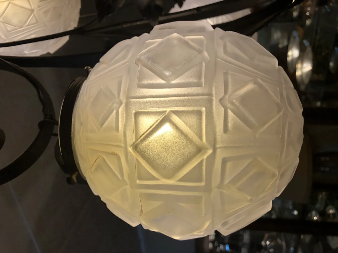 Antique hanging lamp featuring geometric pattern in elegant setting.