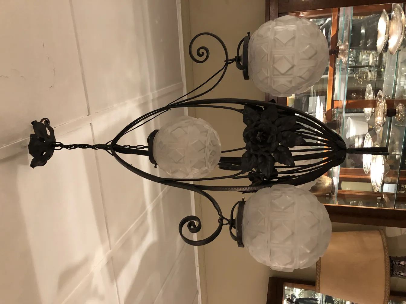 Lâmpada de teto antiga com lâmpadas redondas e design floral, em um ambiente elegante.