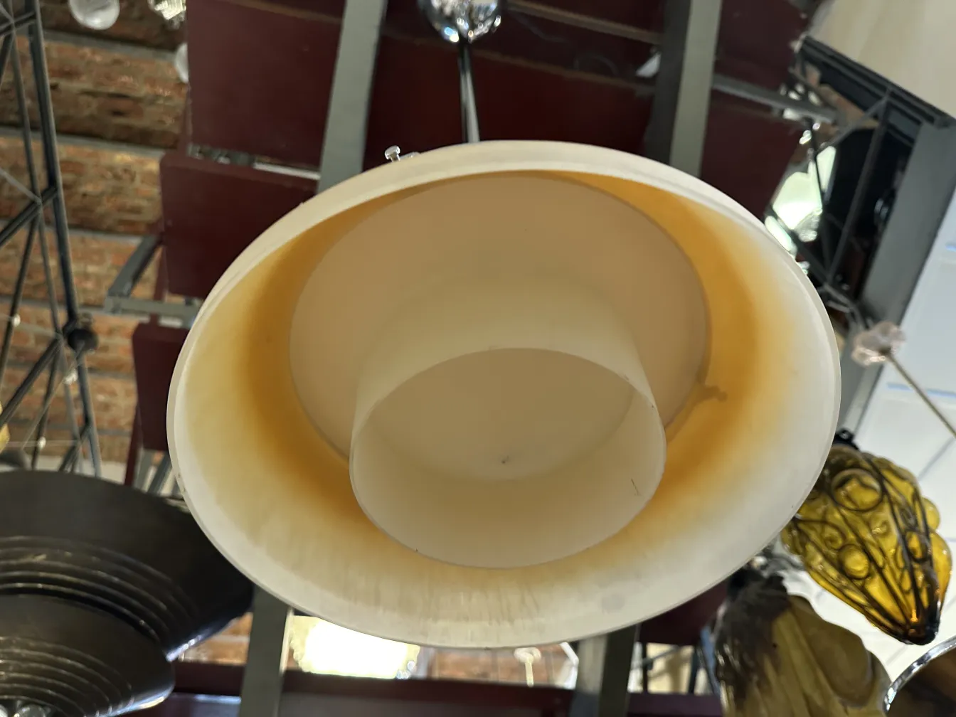 Lustre ancien, au design classique et couleur crème, suspendu au plafond.