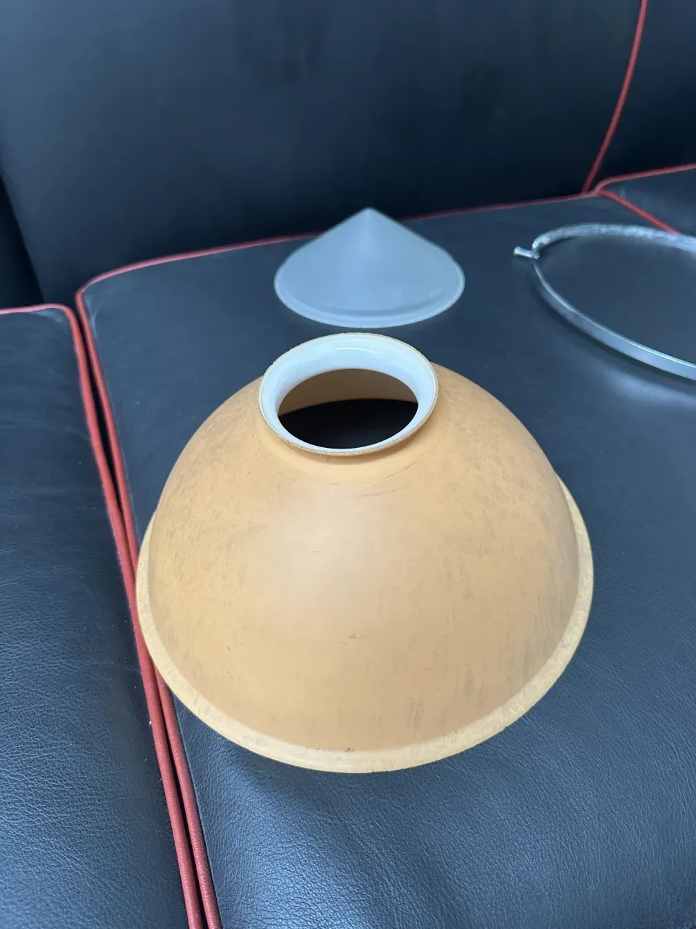 彼得·贝伦斯的古董吊灯在黑暗环境中，表面光滑且弯曲。