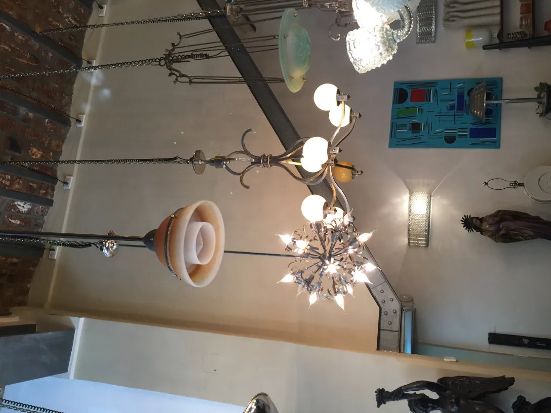 Lâmpada de teto antiga com forma artística, iluminando o espaço.