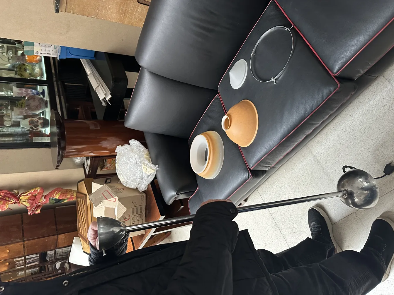 Lampada a sospensione antica con dettagli decorativi e accessori sul tavolo.