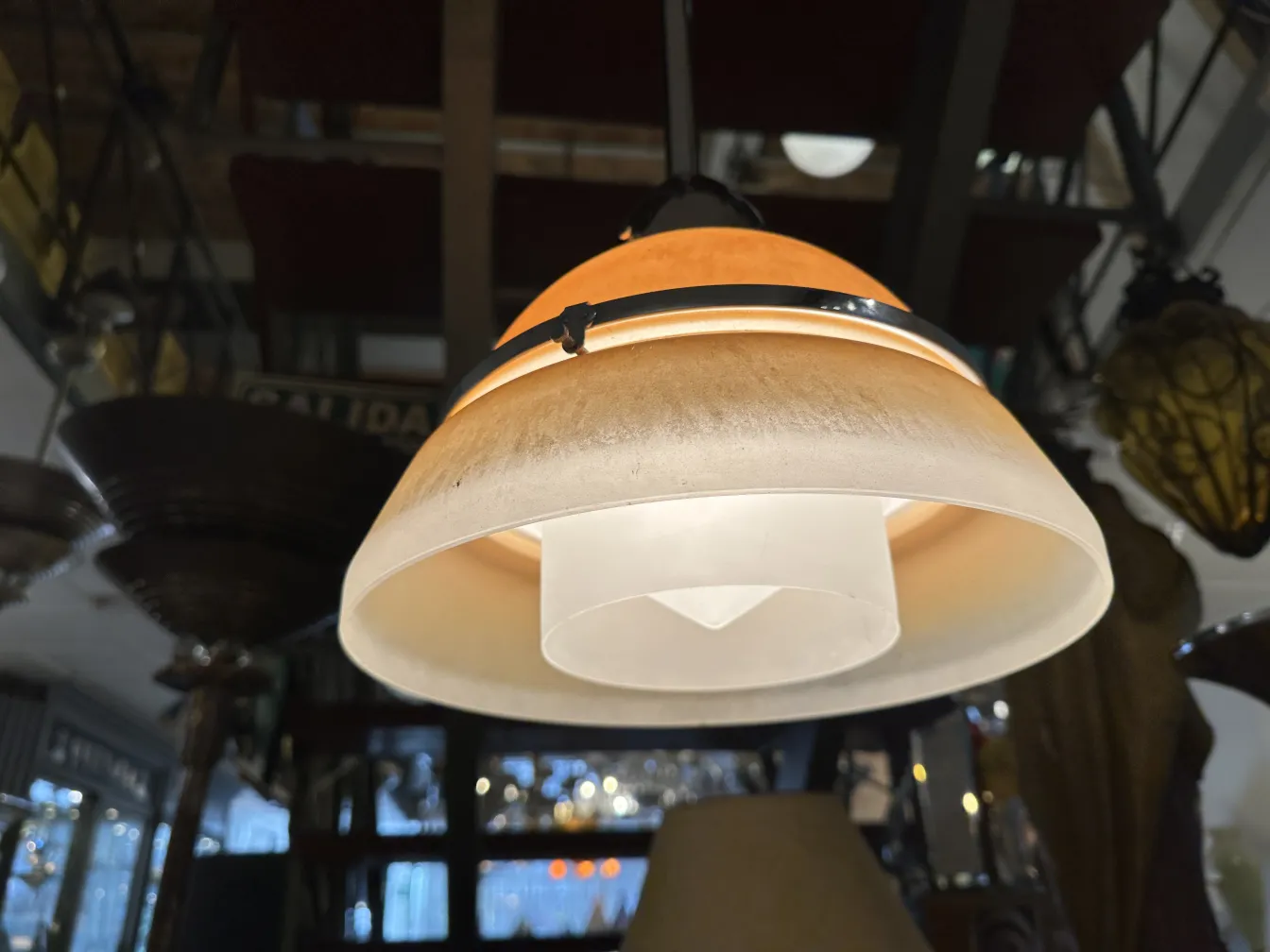 Lámpara de techo antigua con pantalla beige y diseño elegante, iluminando un entorno acogedor.