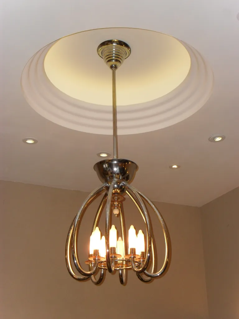 Lámpara de techo antigua con diseño elegante y luces cálidas.