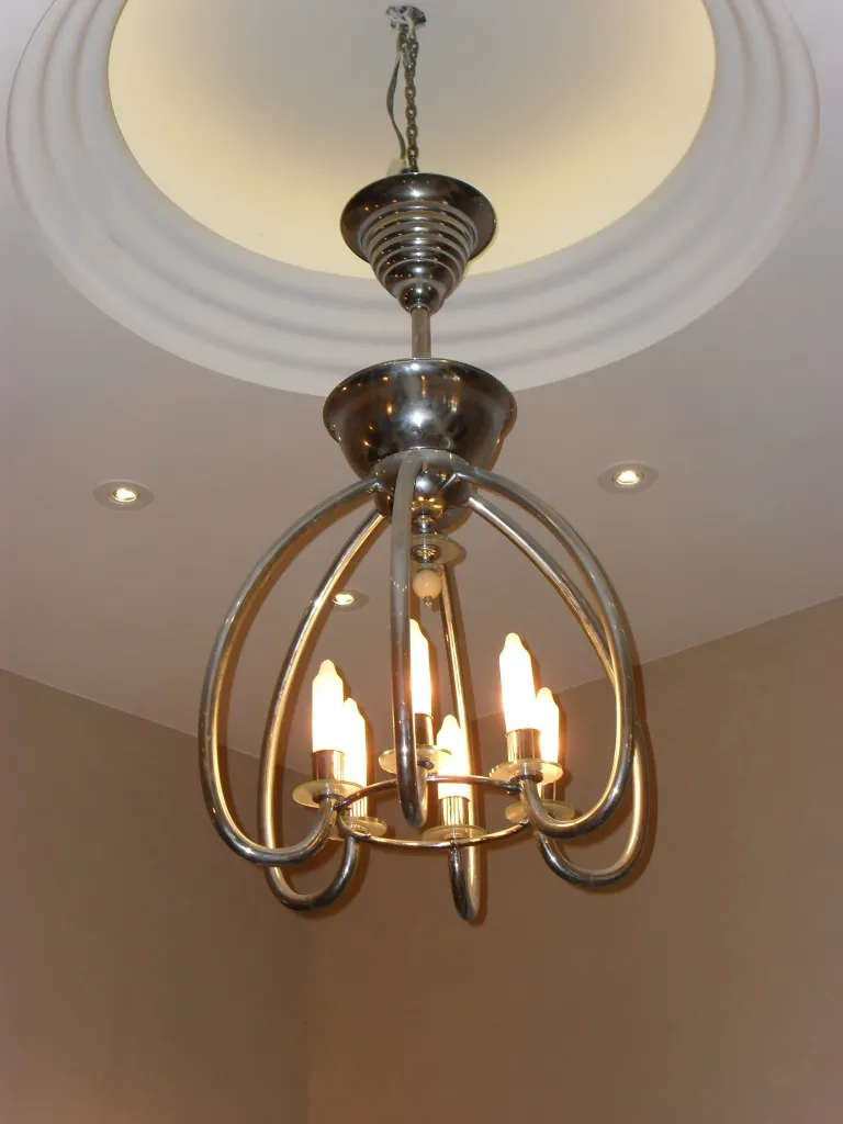 Antike Hängelampe mit glänzendem Metallfinish und modernen Formen.