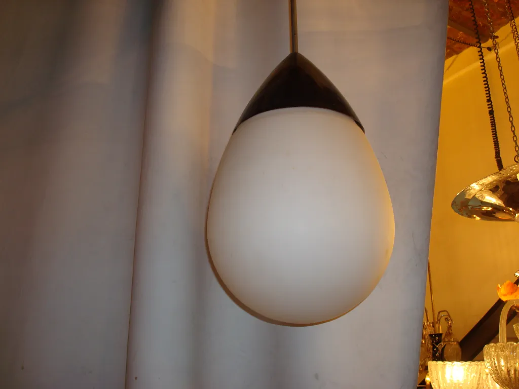 Lámpara de techo antigua de estilo elegante con forma de gota, iluminando un ambiente retro.