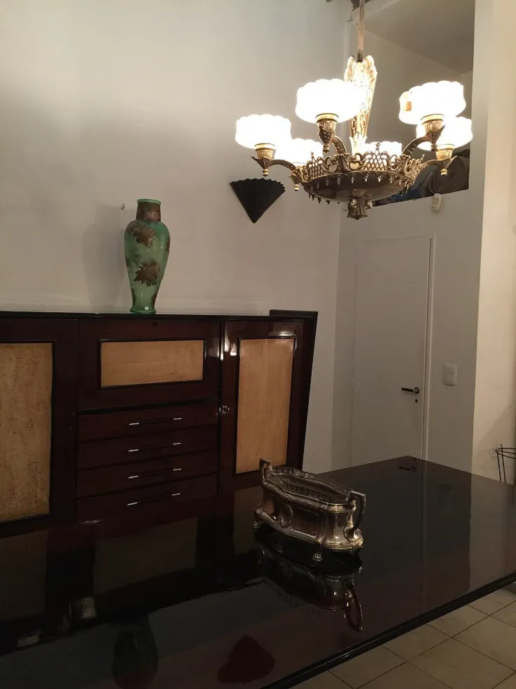 고전적인 확산 빛이 있는 교수형 램프, 우아한 환경에. 녹색 꽃병 옆에.