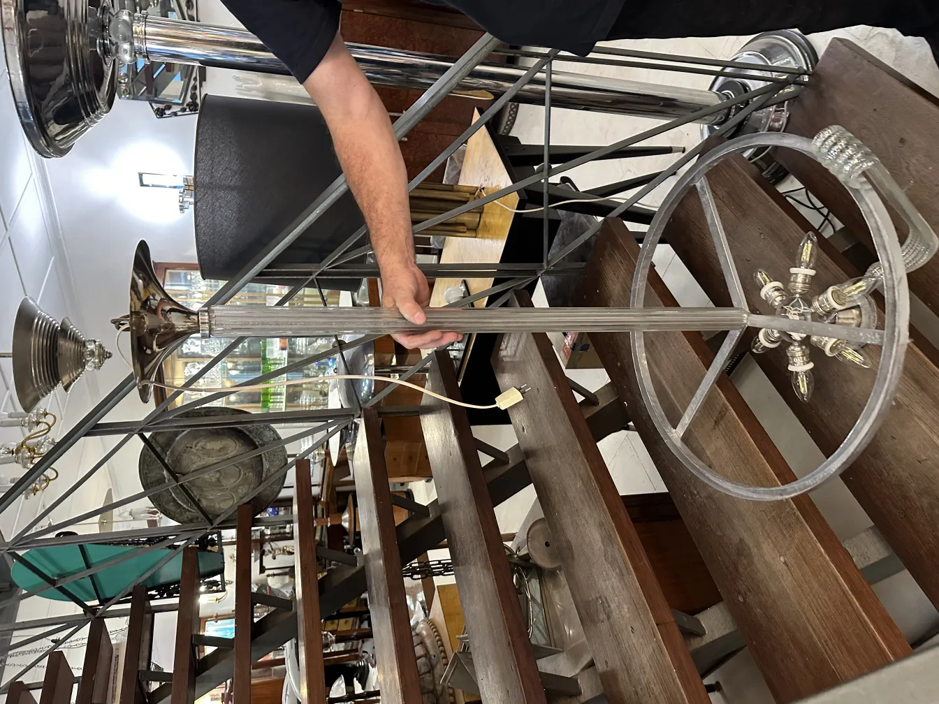 Подвесная лампа старая, яркая, окруженная другими антиквариатами.