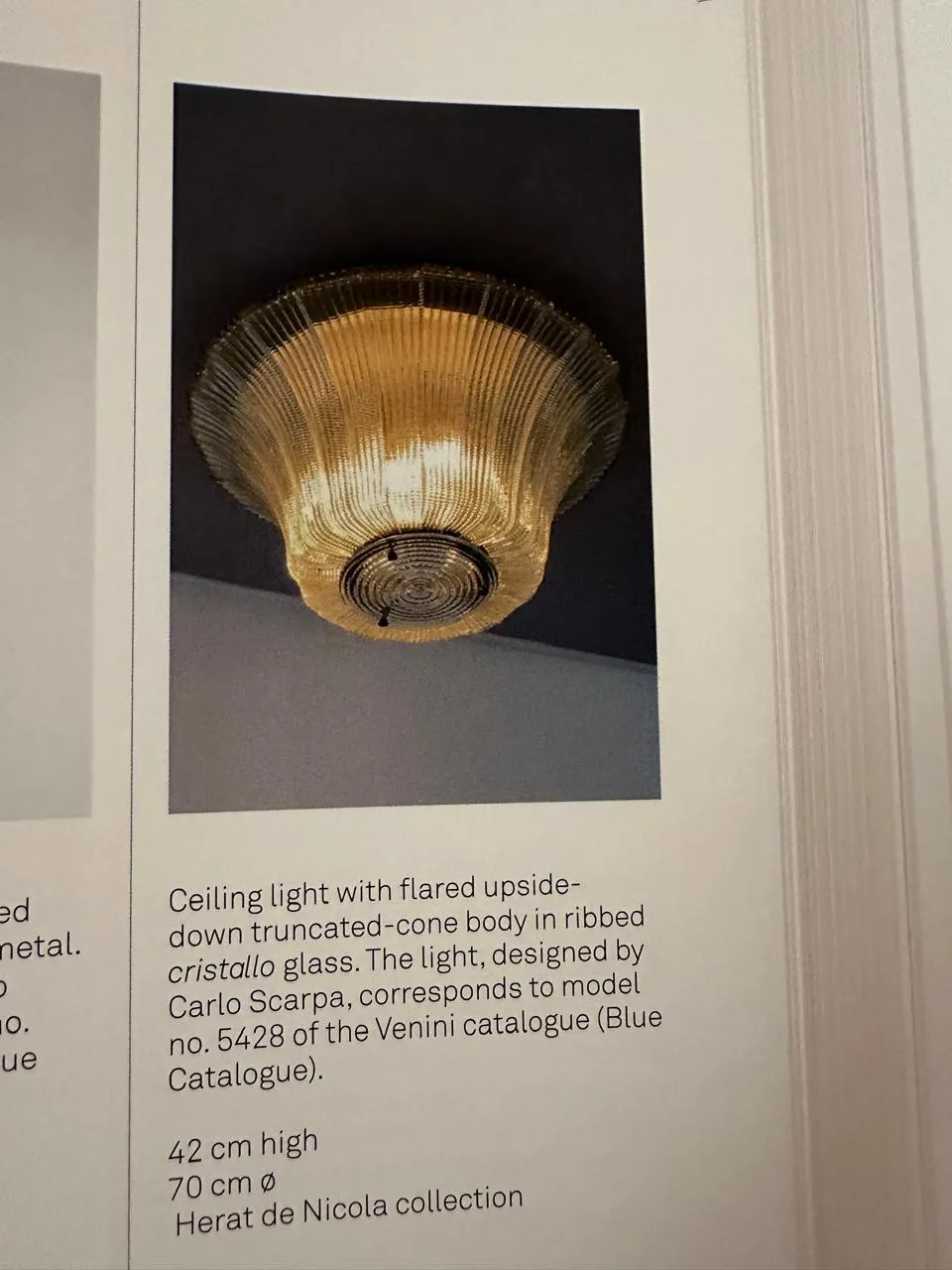 Lámpara de techo antigua de cristal con diseño dividido y fondo oscuro.