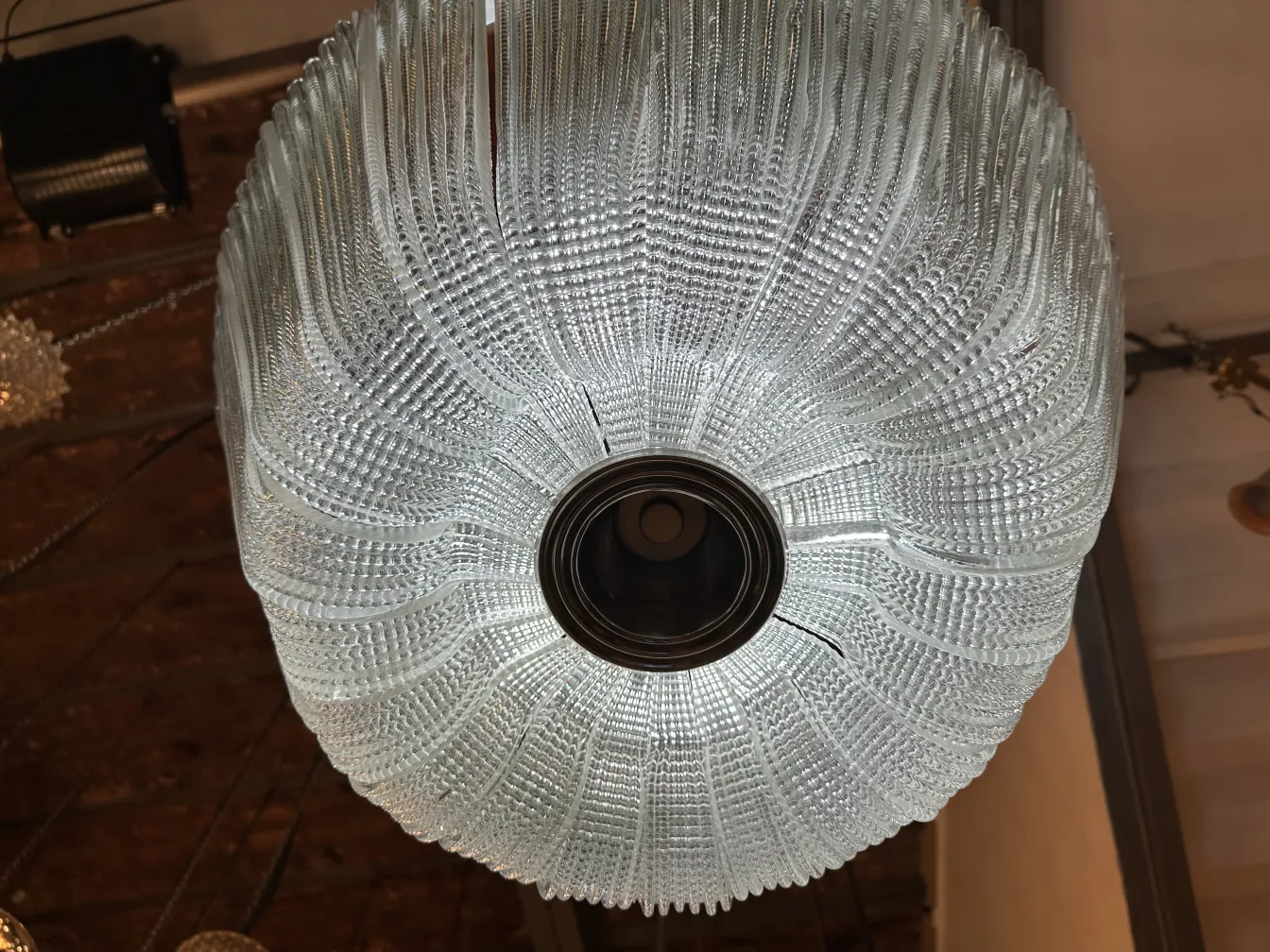 Lustre antique en verre avec des motifs décoratifs.