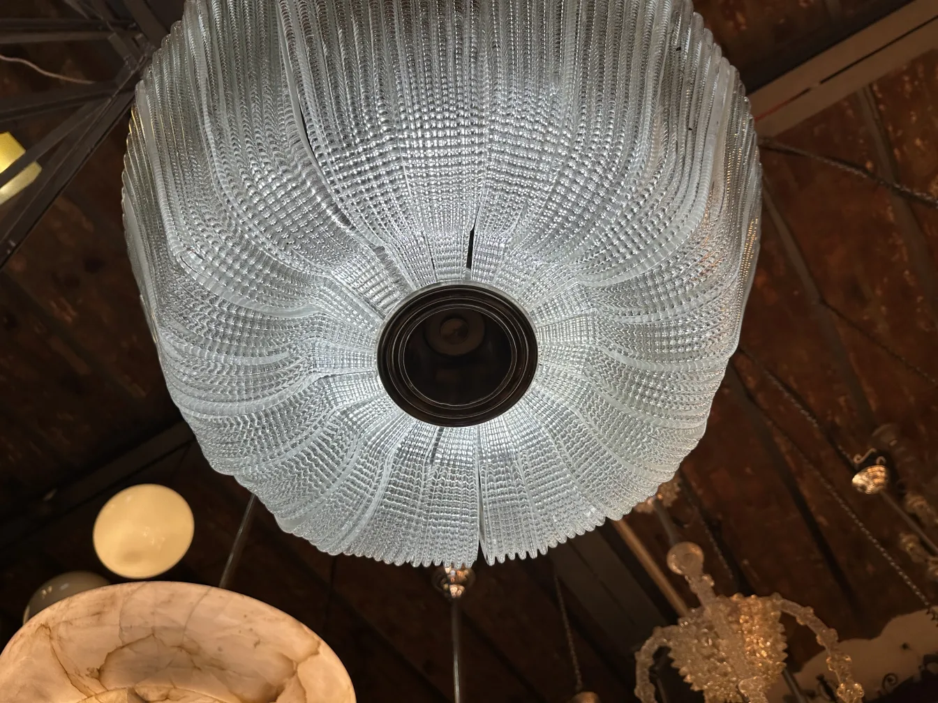 Lampada a sospensione antica in vetro con design elegante in un ambiente accogliente.