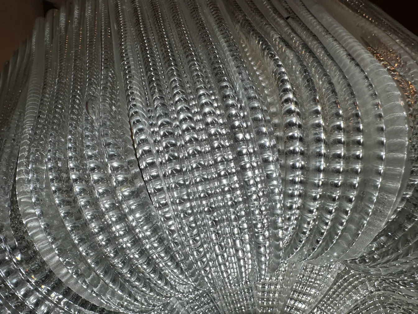 Lâmpada de teto antiga transparente com design curvado.