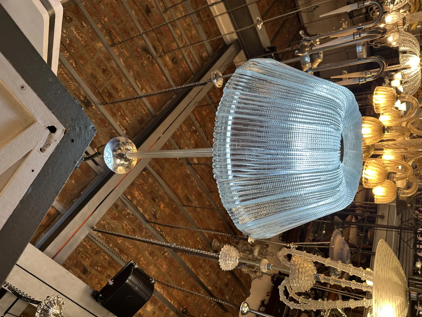 Lâmpada de teto antiga de vidro com design elegante, iluminando um ambiente rústico.