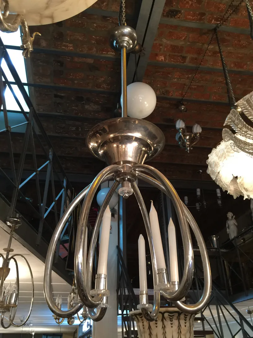 Lampada a sospensione antica con design fluido ed elegante in un ambiente accogliente.