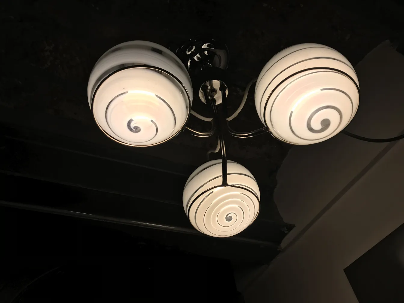 Lampada a sospensione antica con design a spirale e tre lampadine.