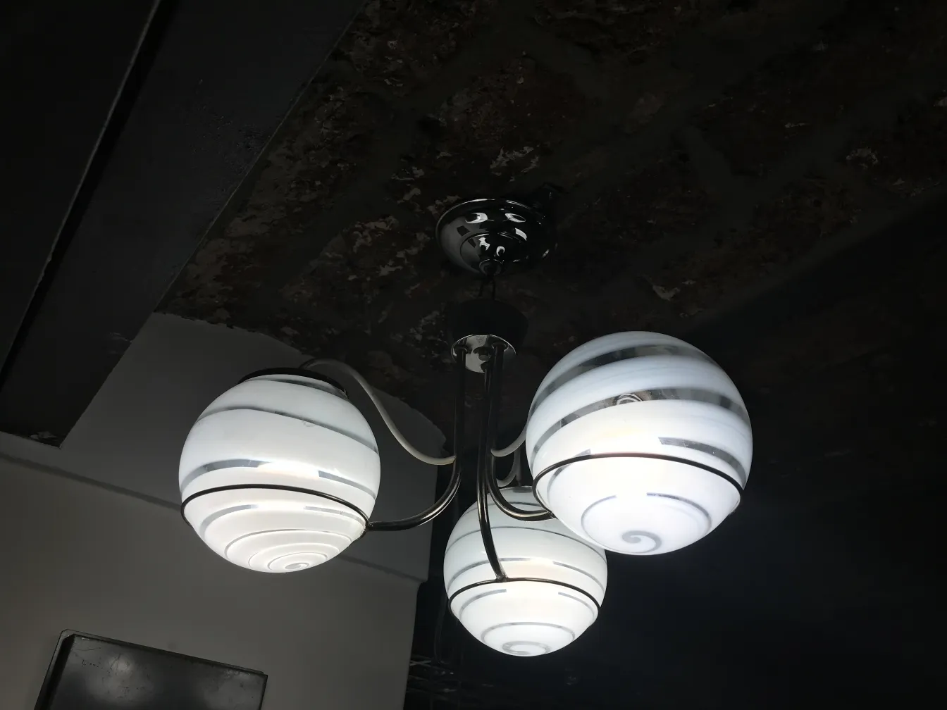 Lâmpada de teto antiga com esferas brancas em um ambiente moderno