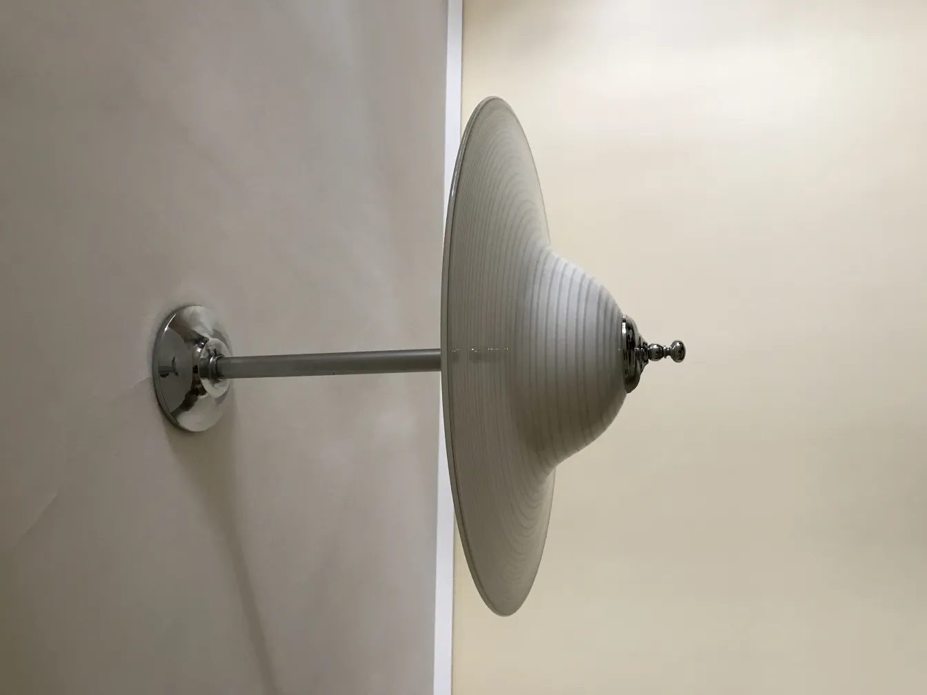 Lámpara de techo antigua con base brillante en un ambiente neutro.