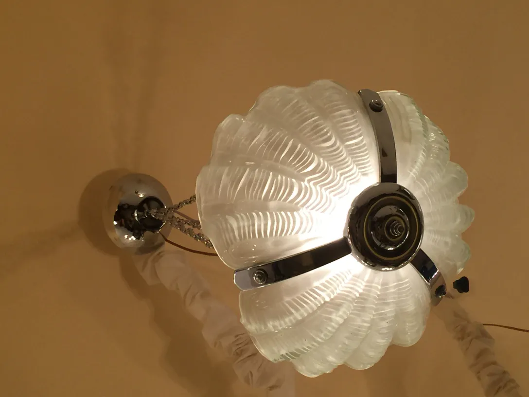 Antike Hängelampe mit dekorativem Blumendesign, das eine warme Atmosphäre beleuchtet.