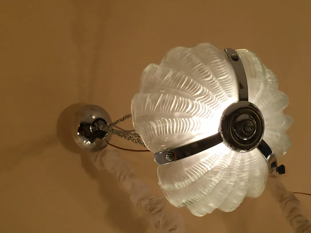 Elegante antike Hängelampe aus Glas mit silbernen Details, die eine warme Atmosphäre schafft.