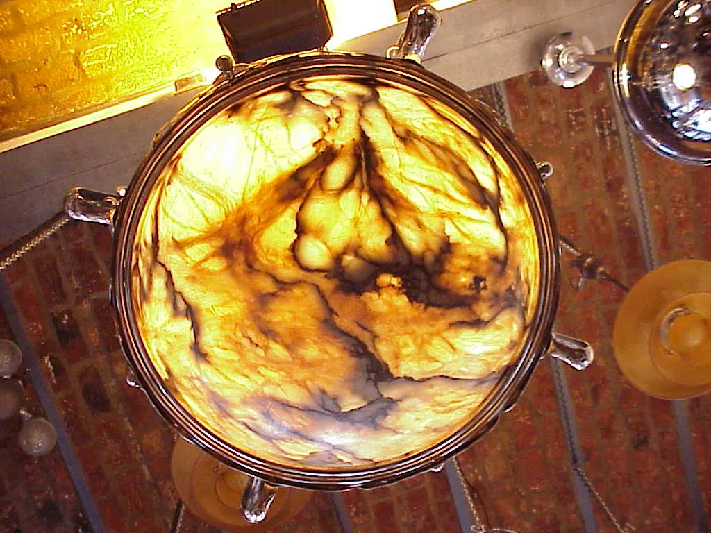 Lampada de techo antigua con diseño artístico en tonos cálidos, ambiente acogedor.