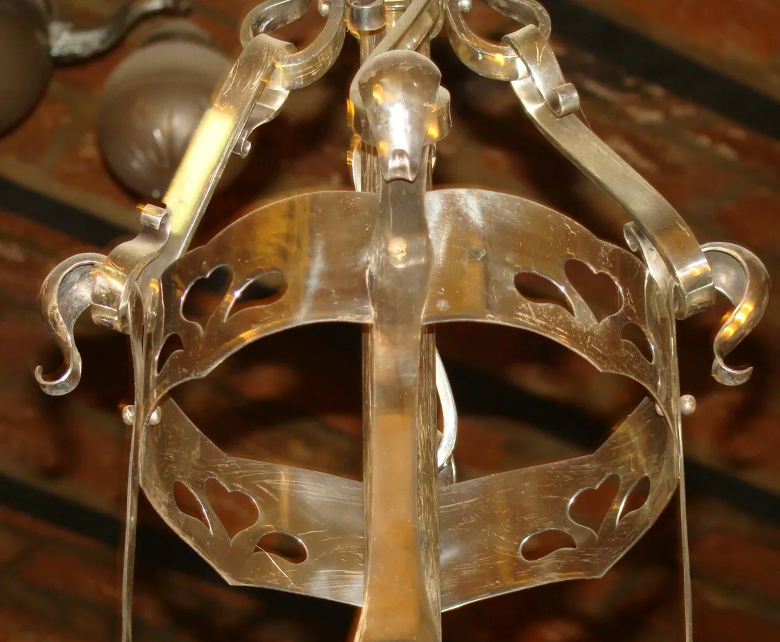 antique hanging lamp with decorative heart-shaped details in a rustic setting