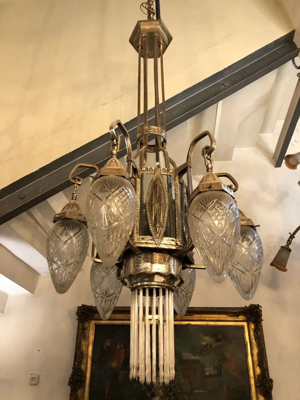 Lâmpada de teto antiga com detalhes em cristal em um ambiente clássico.