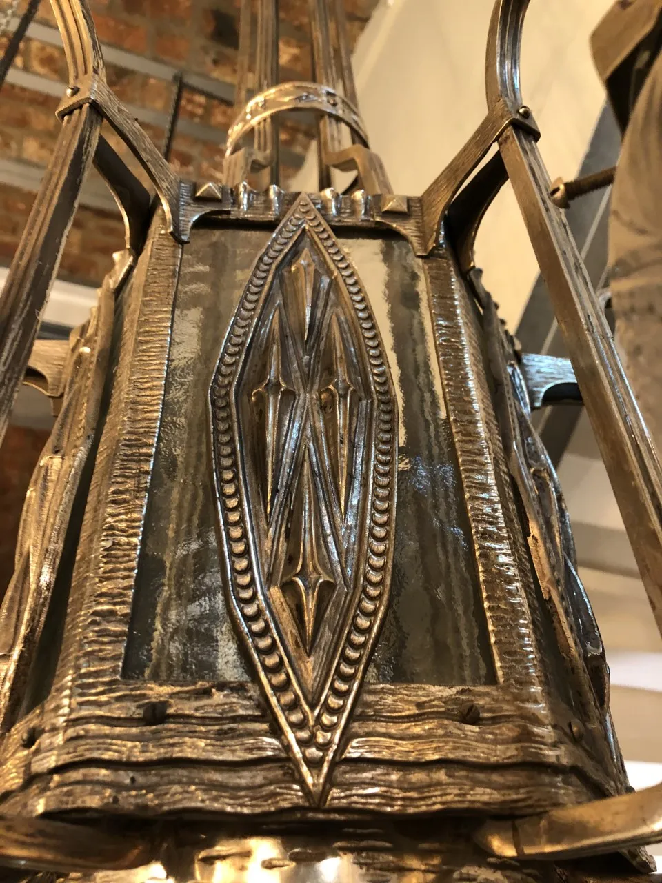 Antique hanging lamp with intricate metal details, in a vintage setting.