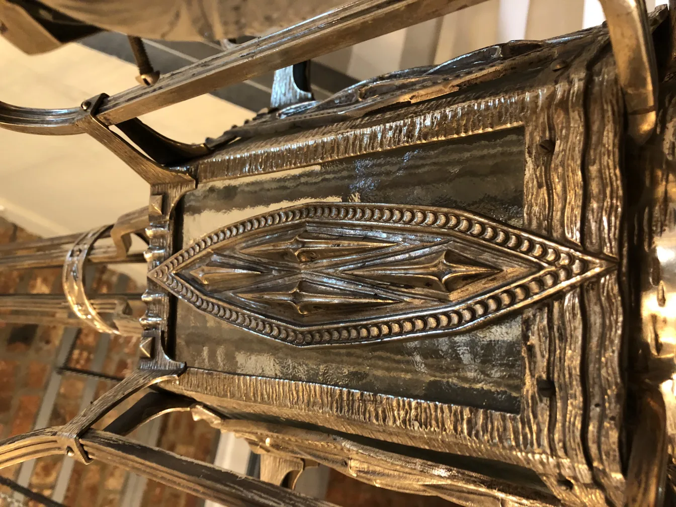 Lâmpada de teto antiga com detalhes intrincados em um ambiente aconchegante.