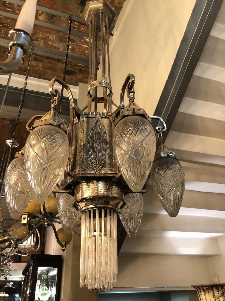 Ancien lustre avec détails en cristal et un design élégant, situé dans un intérieur chaleureux.