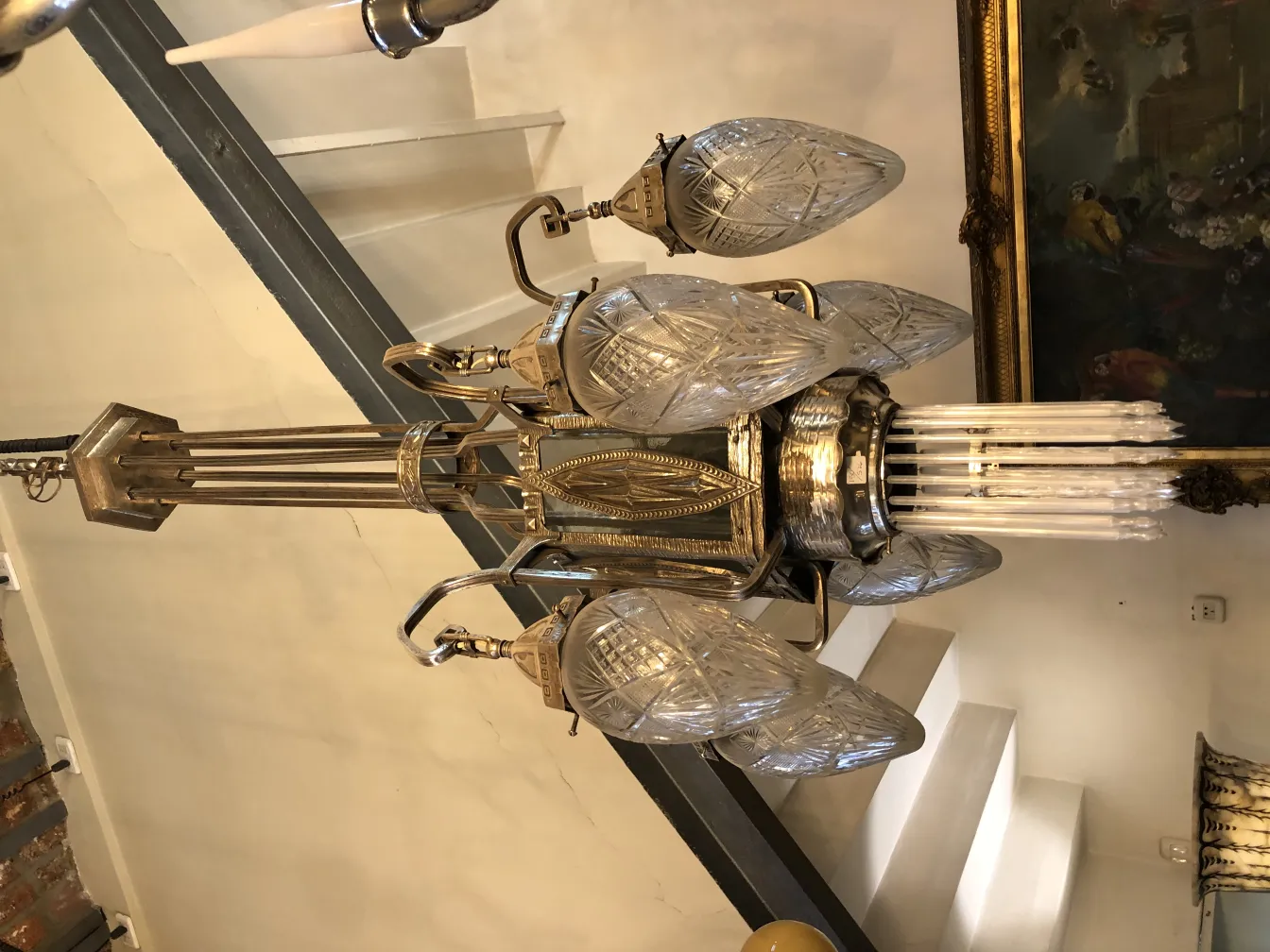 Ancien lustre affichant des designs complexes et des ampoules suspendues.