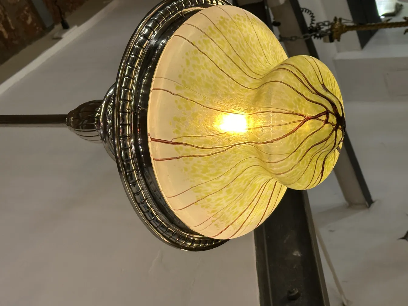 Antike Hängelampe aus buntem Glas, die den Raum erhellt, Teil eines Dekors.