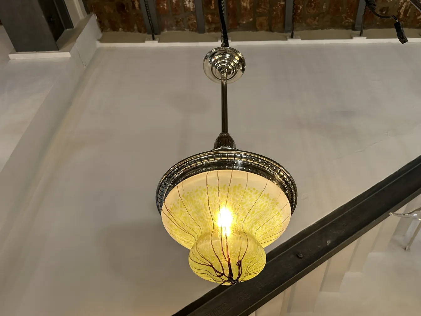 Lustre ancien avec des détails colorés et une lumière chaleureuse dans un cadre accueillant.