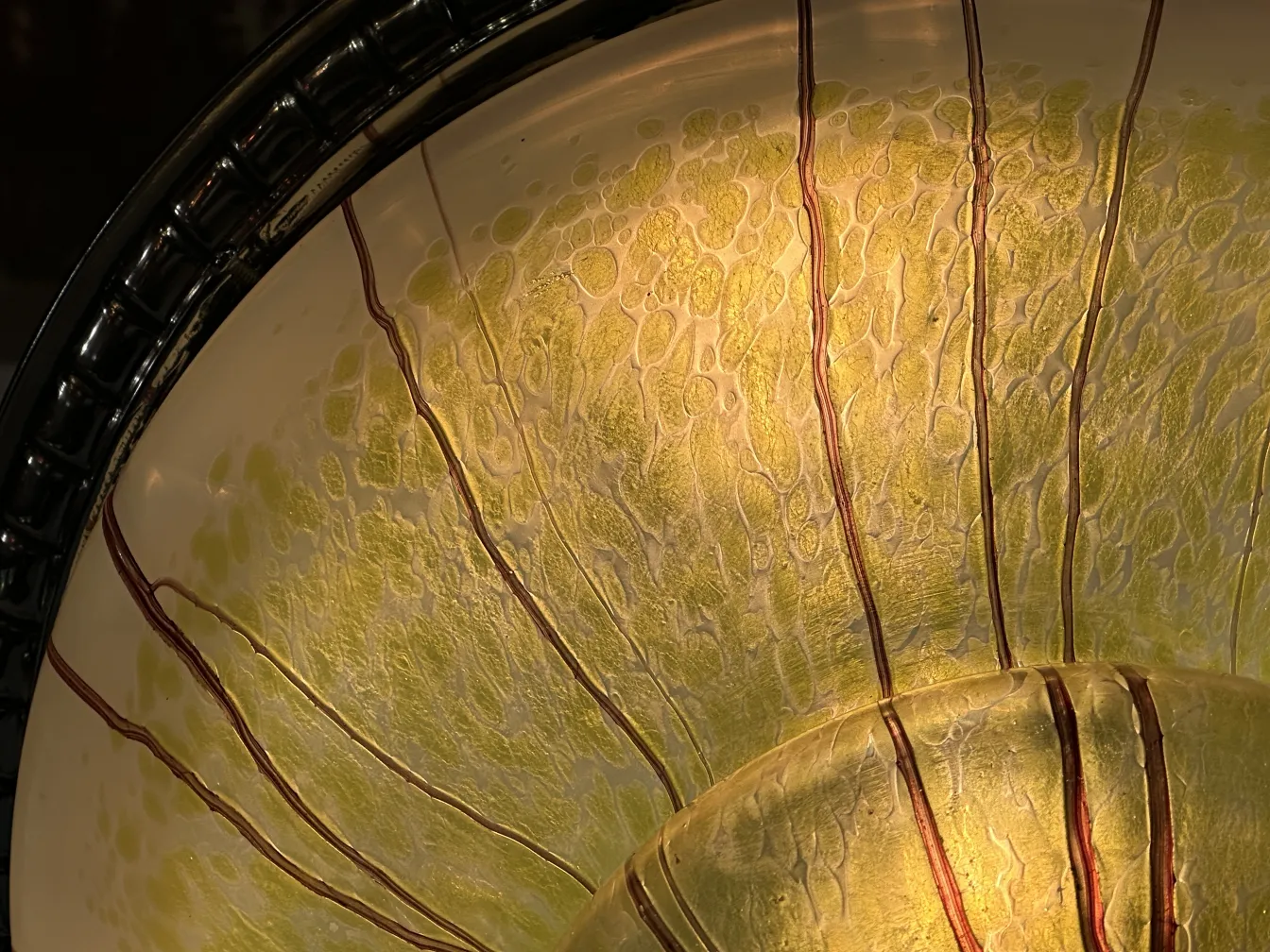 Close-up do interior amarelo e verde de uma lâmpada de teto antiga