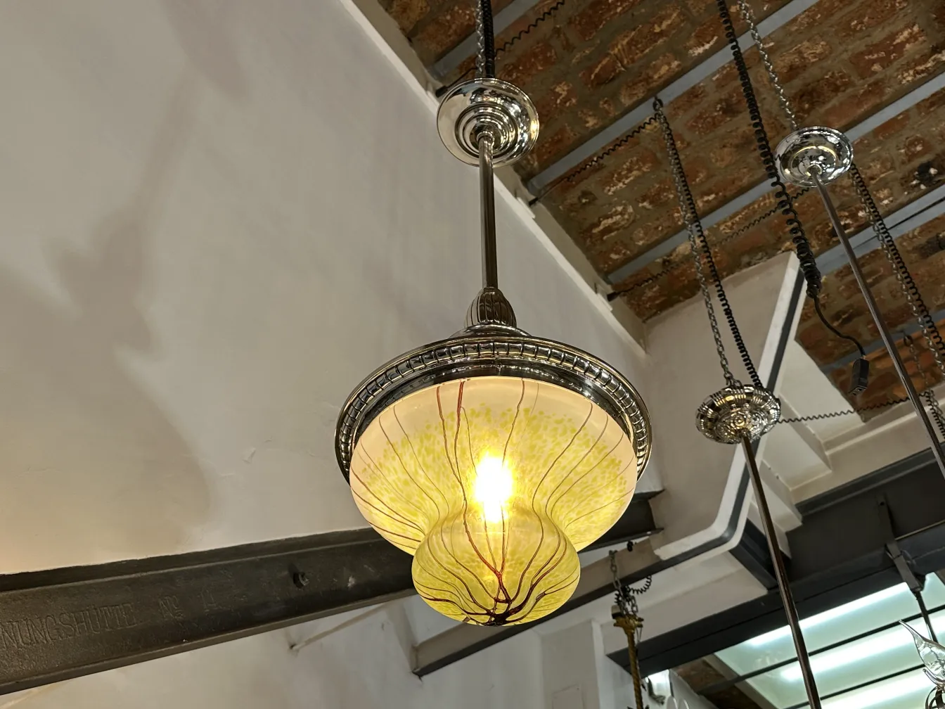 Старая желтая подвесная лампа с тонкой отделкой.