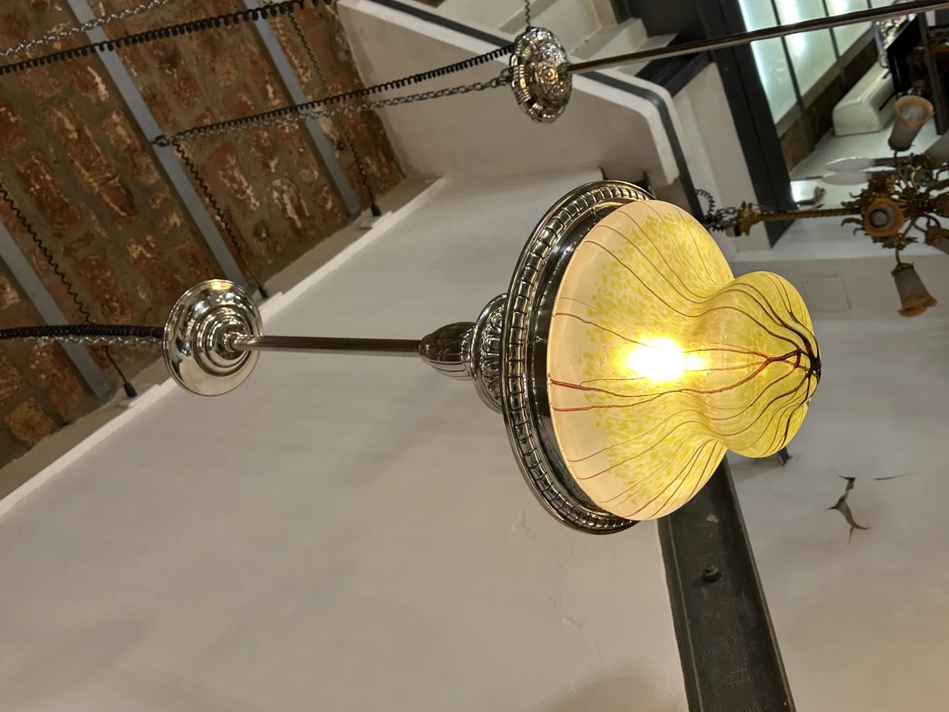 Antike Hängelampe mit hellem, buntem Design in einer gemütlichen Umgebung.